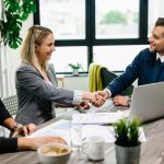 Kobieta podpisuje bezpieczną umowę kredytową w banku, uśmiechając się do doradcy finansowego